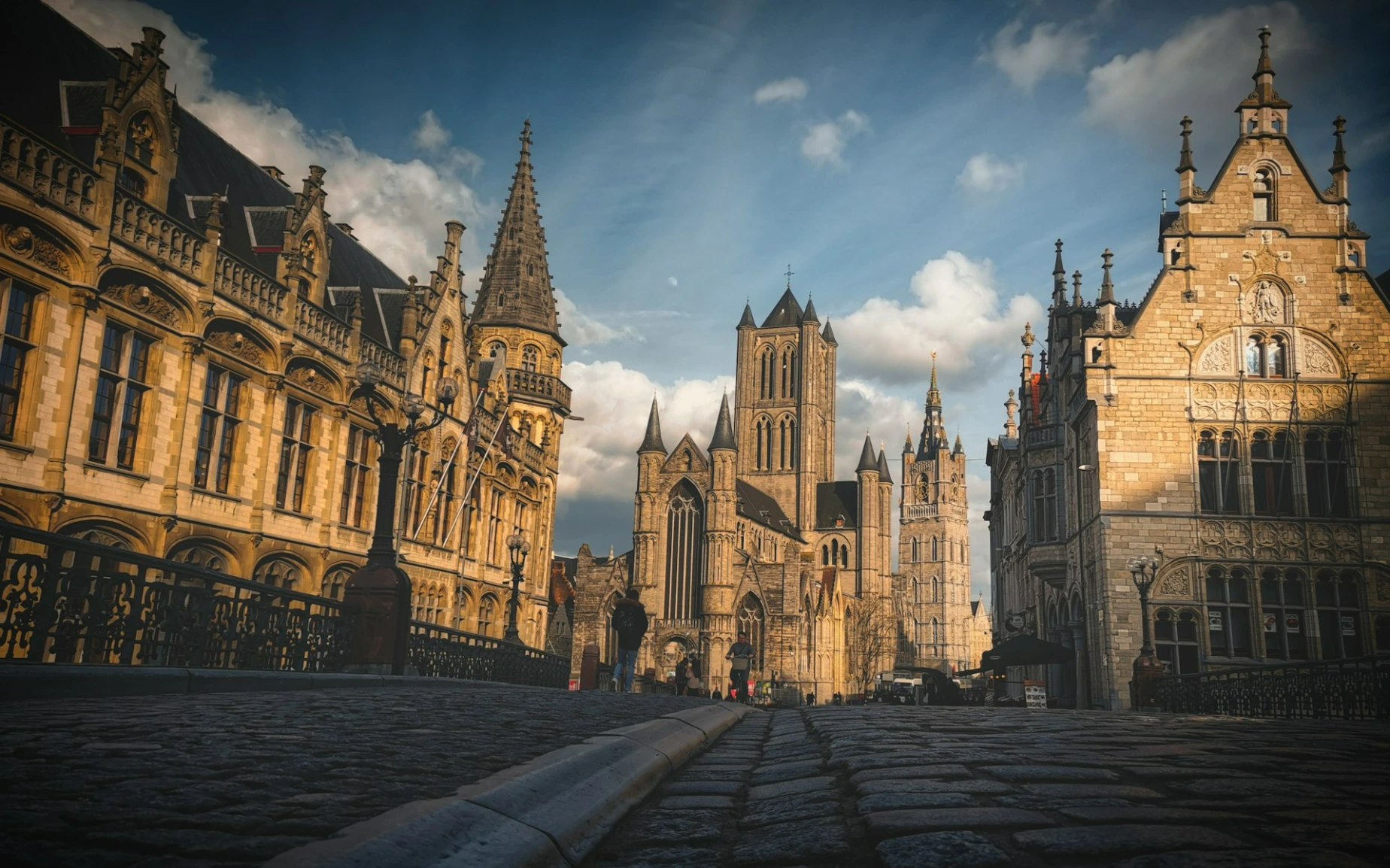 a city street lined with tall buildings under a cloudy sky